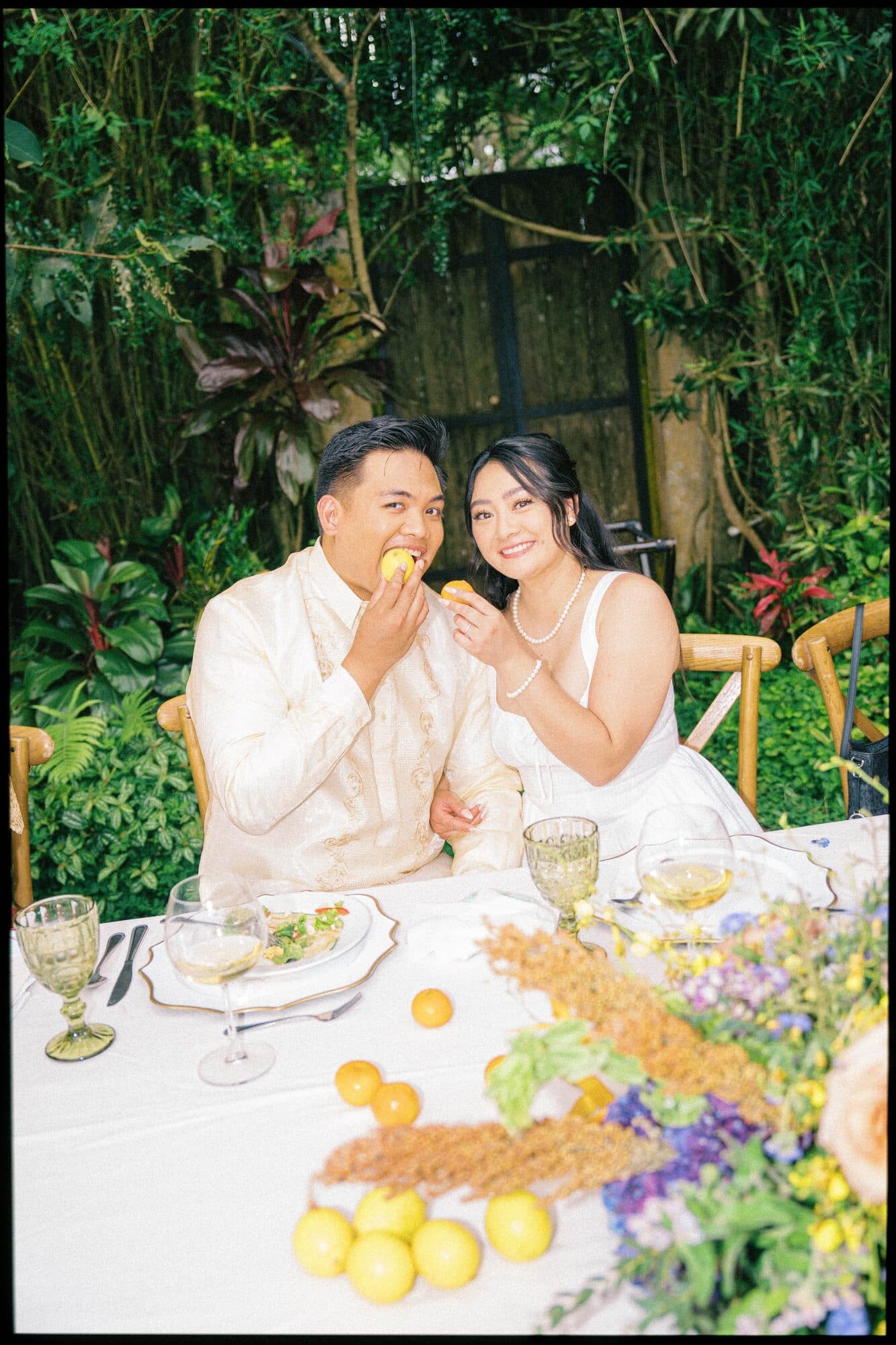 The couple seated at the head table feeding each other, lemons and wildflowers running down the centre of the table