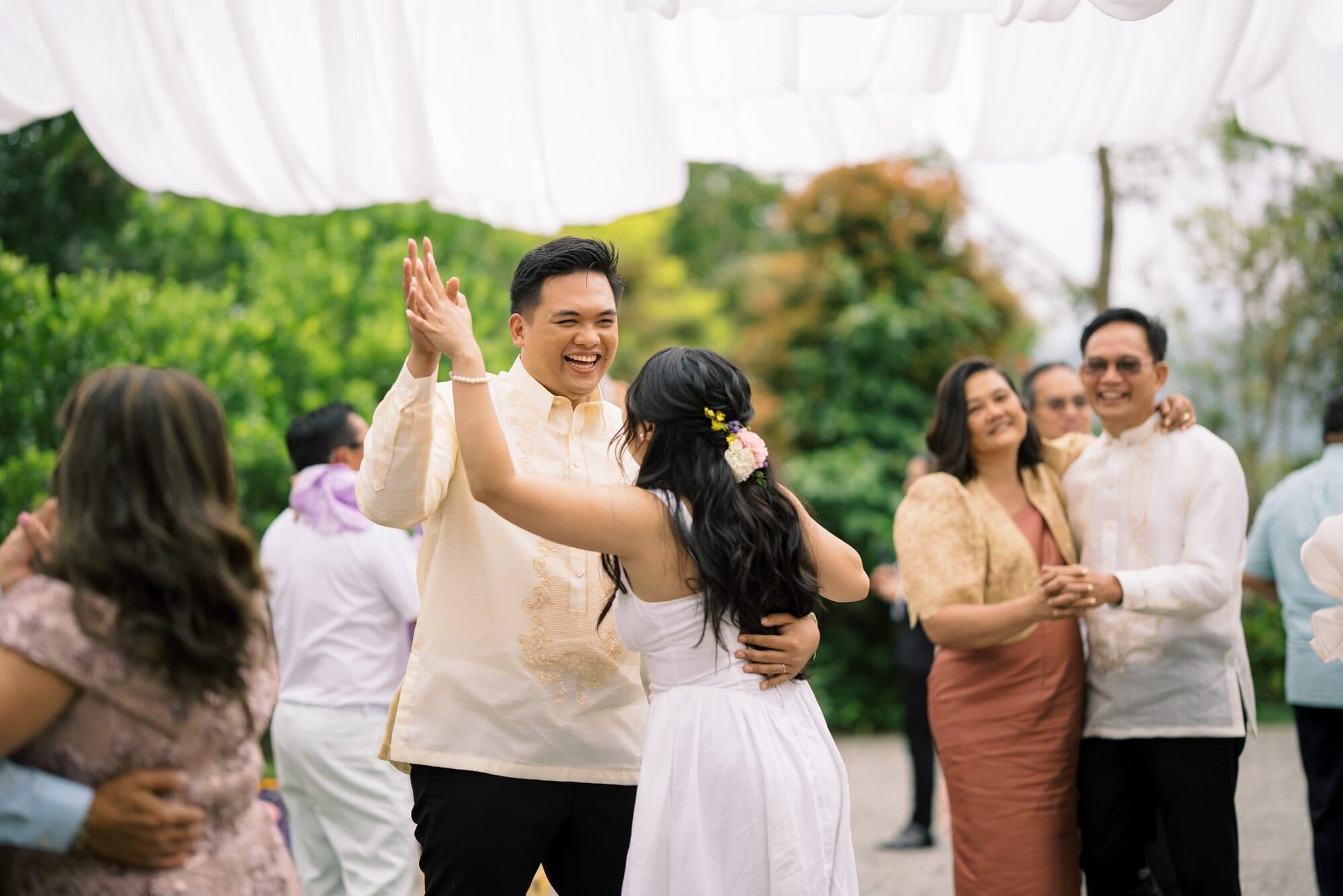 The groom twirling the bride on the gravel dance floor while other couples dance around them