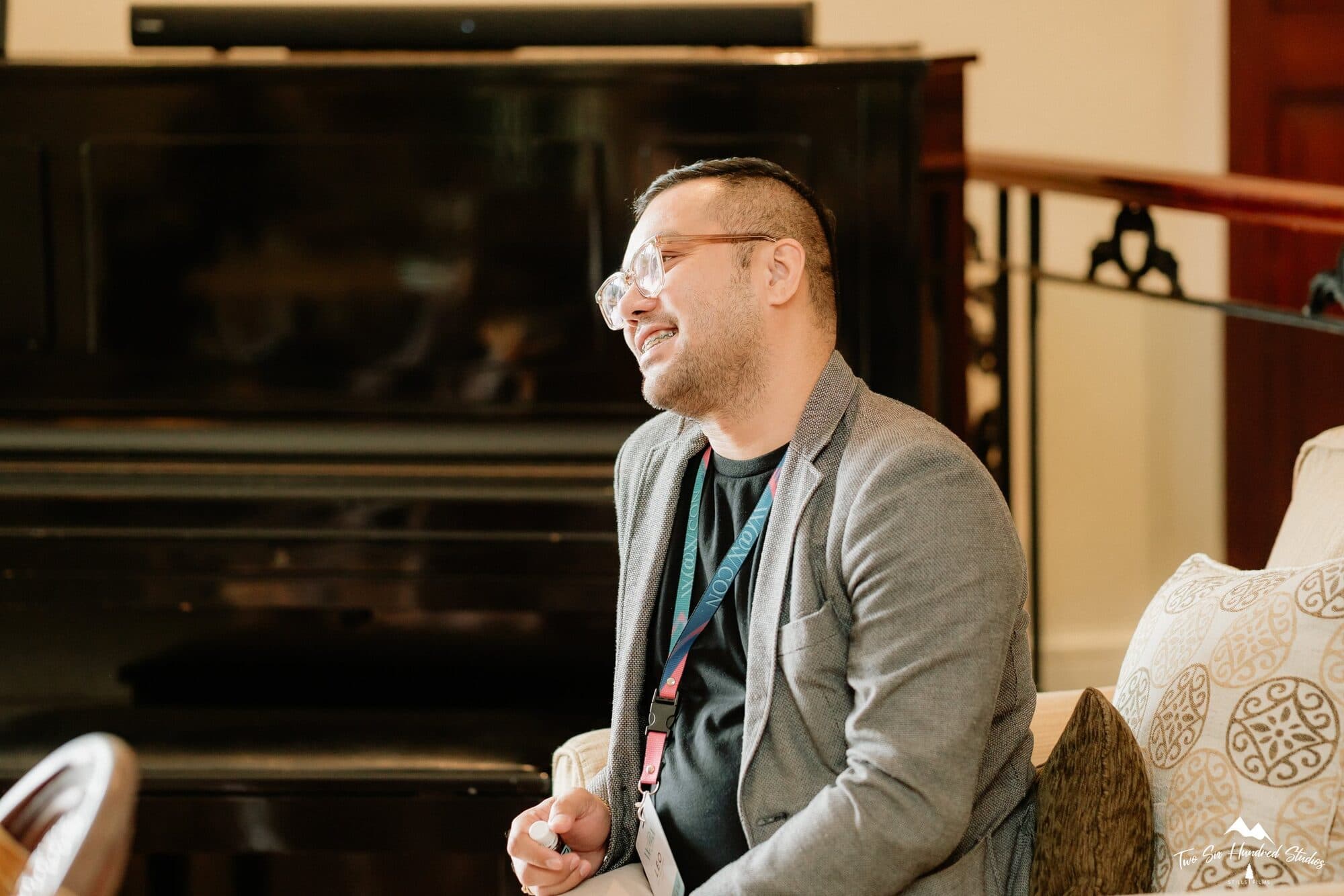 Leo Vidallon seated beside the piano, smiling during the afternoon conversation