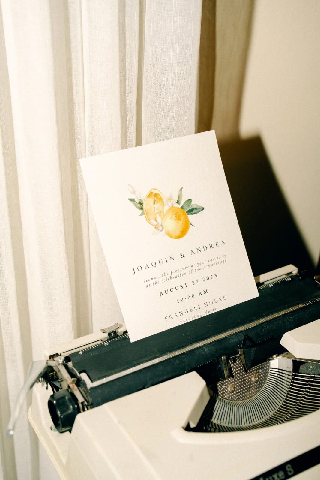 A typewriter and wedding invitation suite on a desk