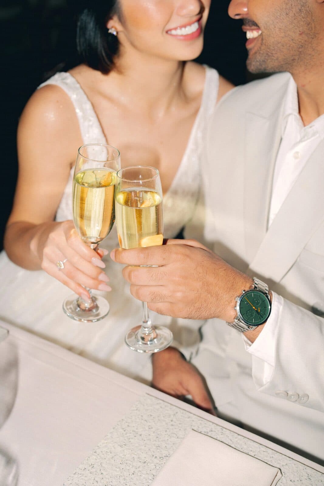 A couple toasting with champagne at their reception table